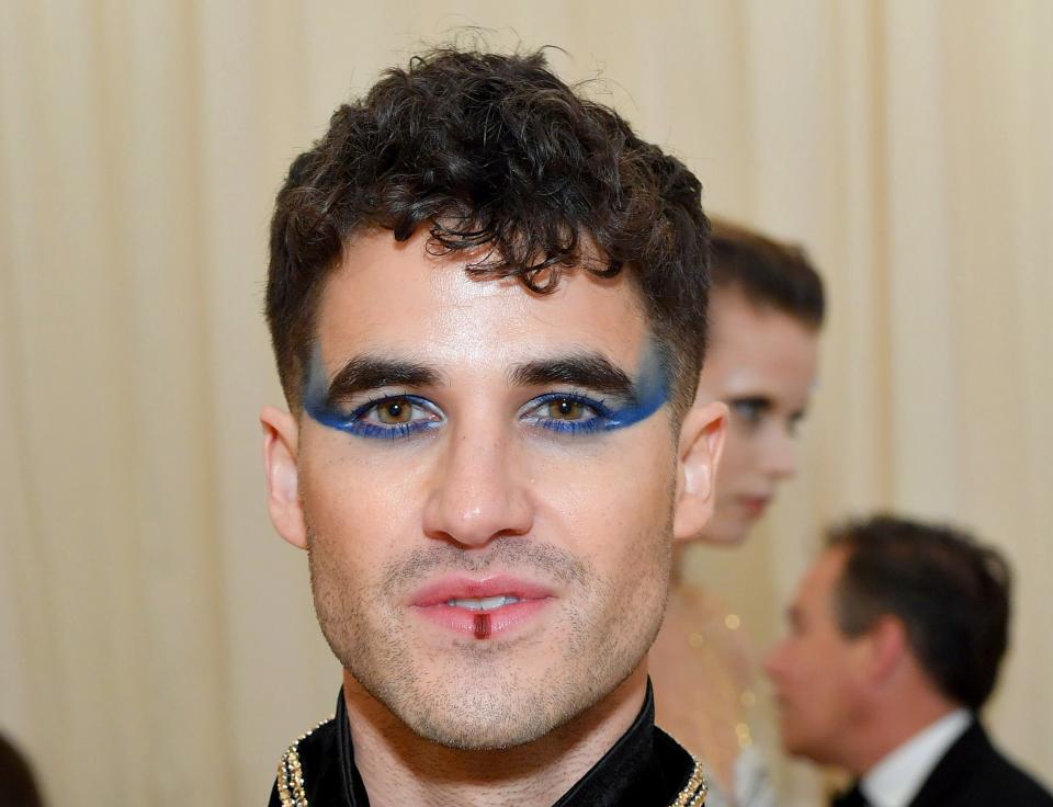 Darren with bold eye makeup and jeweled outfit at an event