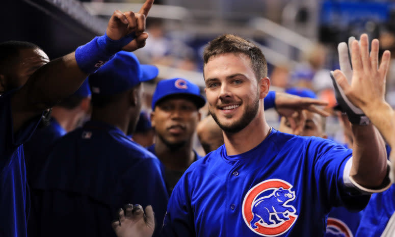 Kris Bryant high-fiving his teammates in the dugout.