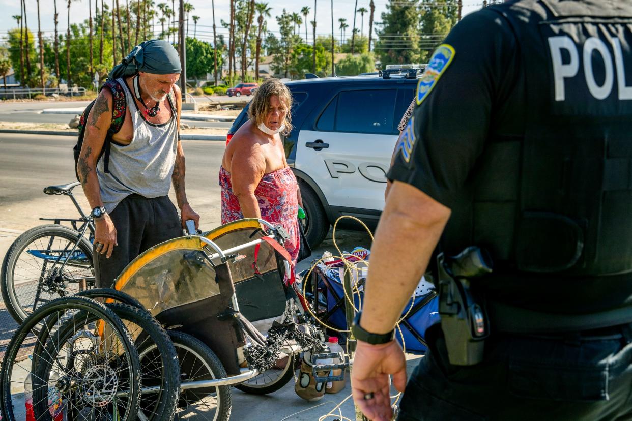 Steve Grant, left, and Rose Marie Allen look over their belongings to decide what they hope to bring to the Coachella Valley Rescue Mission after accepting shelter during Operation Clean Streets in Palm Springs, Calif., on Tuesday, Sept. 13, 2022. Tuesday's operation by the Palm Springs Police Department's Homeless Outreach and Probation teams was the sixth in ongoing operations to get help for the unhoused through shelter connection, rehabilitation, or arrest.  