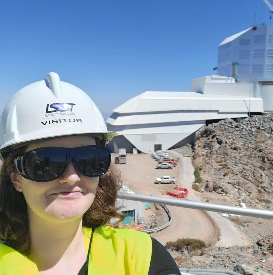 Erin Howard poses on the summit of Chile's Cerro Pachón with the Vera C. Rubin observatory. Howard, a Bremerton native and Olympic College graduate, is part of the team erecting what will be the largest camera ever built for astronomy and astrophysics and planned to go online in 2025.