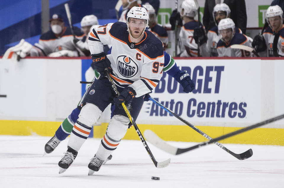 FILE - In this Tuesday, May 4, 2021 file photo, Edmonton Oilers' Connor McDavid skates with the puck during the first period of an NHL hockey game in Vancouver, British Columbia. The Edmonton captain is in a class by himself with a league-high 104 points in 55 games as the likely Hart Trophy winner as the NHL's MVP. The Oilers will be playing Winnipeg in their first-round series, the team McDavid had the most points against this season with 22 in nine games played. (Darryl Dyck/The Canadian Press via AP, File)