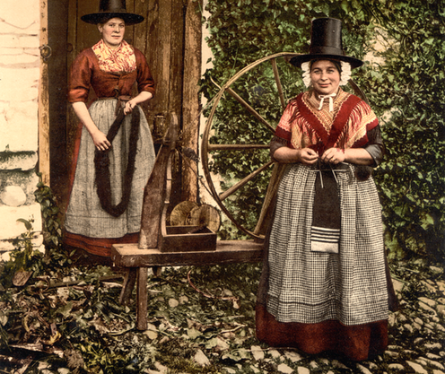 <span class="caption">Welsh weavers, here in traditional costume that would not have been known to some of the poorest weavers to benefit from slave-driven demand for cloth.</span> <span class="attribution"><a class="link " href="https://en.wikipedia.org/wiki/File:Welsh_spinners_and_spinning_wheel,_Wales-LCCN2001703565.tif" rel="nofollow noopener" target="_blank" data-ylk="slk:Detroit Publishing Co/Library of Congress;elm:context_link;itc:0;sec:content-canvas">Detroit Publishing Co/Library of Congress</a></span>