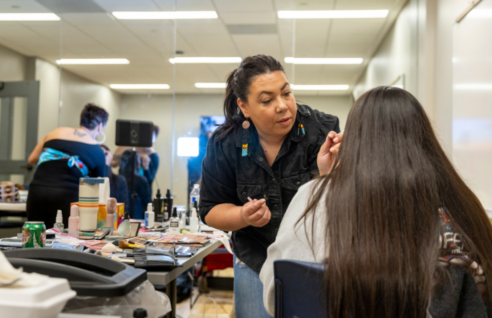 <em>Makeup artists prepare models backstage during an Indigenous fashion show in the Montana State University American Indian Hall in Bozeman. MSU. (Photo/Marcus "Doc" Cravens)</em>