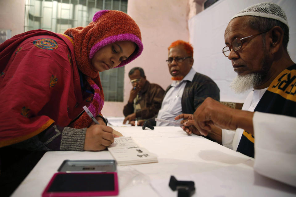 A Bangladeshi woman writes her signature to receive a ballot paper before casting her vote at a polling station in Dhaka, Bangladesh, Sunday, Jan. 5, 2014. Voting has started in Bangladesh for general elections Sunday that threaten to deepen the crisis in the South Asian nation. The opposition and its allies are boycotting the vote, a move that undermines the legitimacy of the election and makes it unlikely that the polls will stem a wave of political violence that killed at least 275 people in 2013. (AP Photo/ Rajesh Kumar Singh)