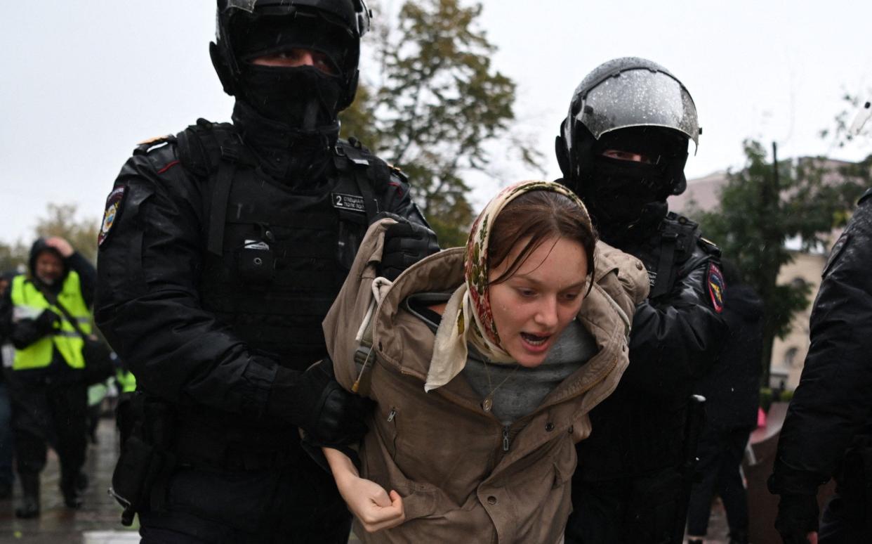 Police officers haul away a female demonstrator during protests in Moscow at the weekend - AFP