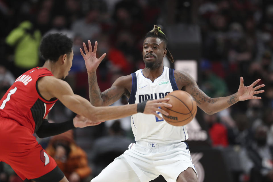 Dallas Mavericks forward Reggie Bullock guards against Portland Trail Blazers guard Anfernee Simons during the first half of an NBA basketball game in Portland, Ore., Wednesday, Jan. 26, 2022. (AP Photo/Amanda Loman)