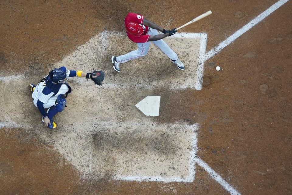 Cincinnati Reds' Aristides Aquino hits an RBI single during the 10th inning of a baseball game against the Milwaukee Brewers Sunday, Aug. 7, 2022, in Milwaukee. (AP Photo/Morry Gash)