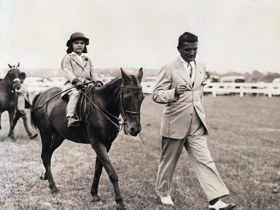 Jacqueline Bouvier rides horseback as her dad, John, walks at her side in East Hampton.