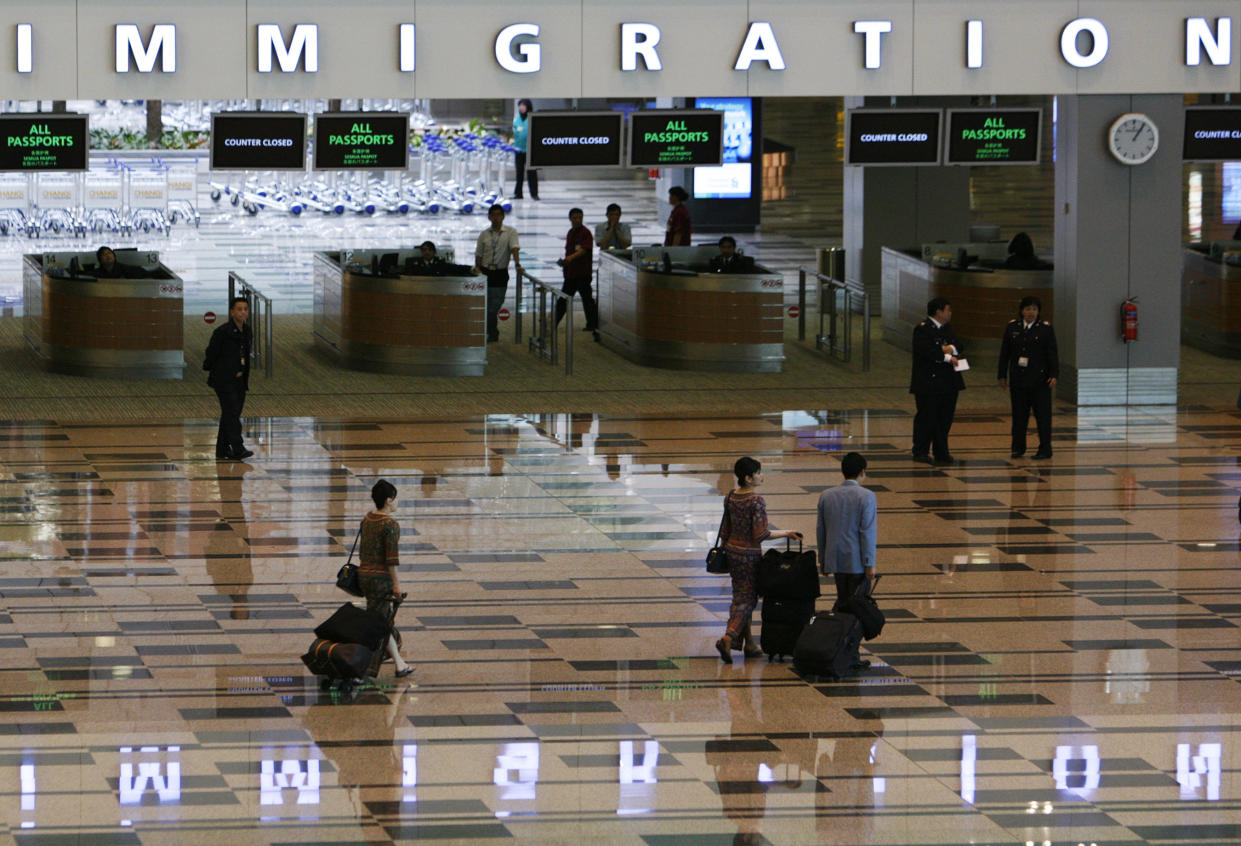 Air crews walk through an immigration hall in the newly opened Terminal 3 at Singapore's Changi Airport January 9, 2008. The terminal, which cost S$1.75 billion ($1.22 billion) to build, is designed to handle up to 22 million passengers a year, boosting Changi Airport's capacity to 70 million passengers annually, according to the Civil Aviation Authority of Singapore (CAAS).  REUTERS/Vivek Prakash (SINGAPORE)