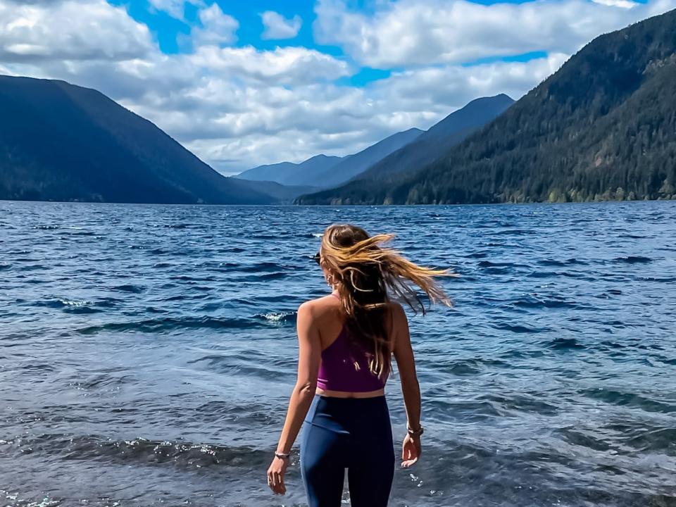 Emily faces the shoreline at a beach in Olympic National Park.