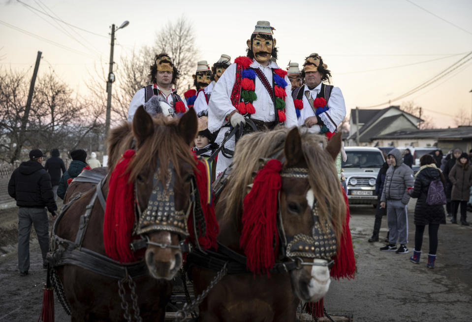 Participants, dressed in traditional costumes, ride in a horse-drawn cart while celebrating the Malanka festival in the village of Krasnoilsk, Ukraine, Friday, Jan. 14, 2022. (AP Photo/Ethan Swope)