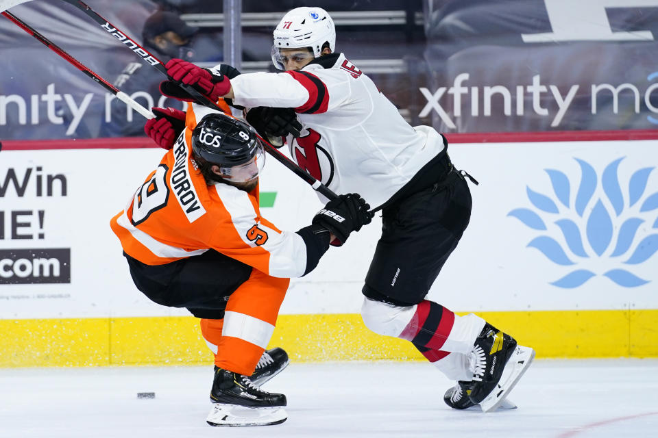 Philadelphia Flyers' Ivan Provorov, left, and New Jersey Devils' Jonas Siegenthaler battle for the puck during the second period of an NHL hockey game, Monday, May 10, 2021, in Philadelphia. (AP Photo/Matt Slocum)