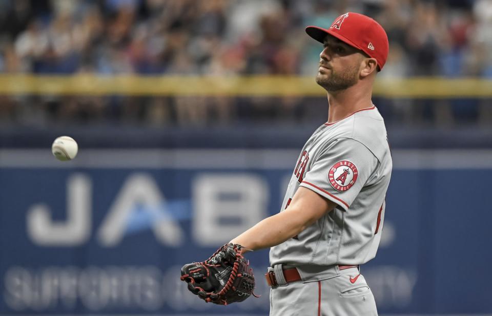 Angels reliever Mike Mayers reaches for a new ball after giving up a three-run home run.