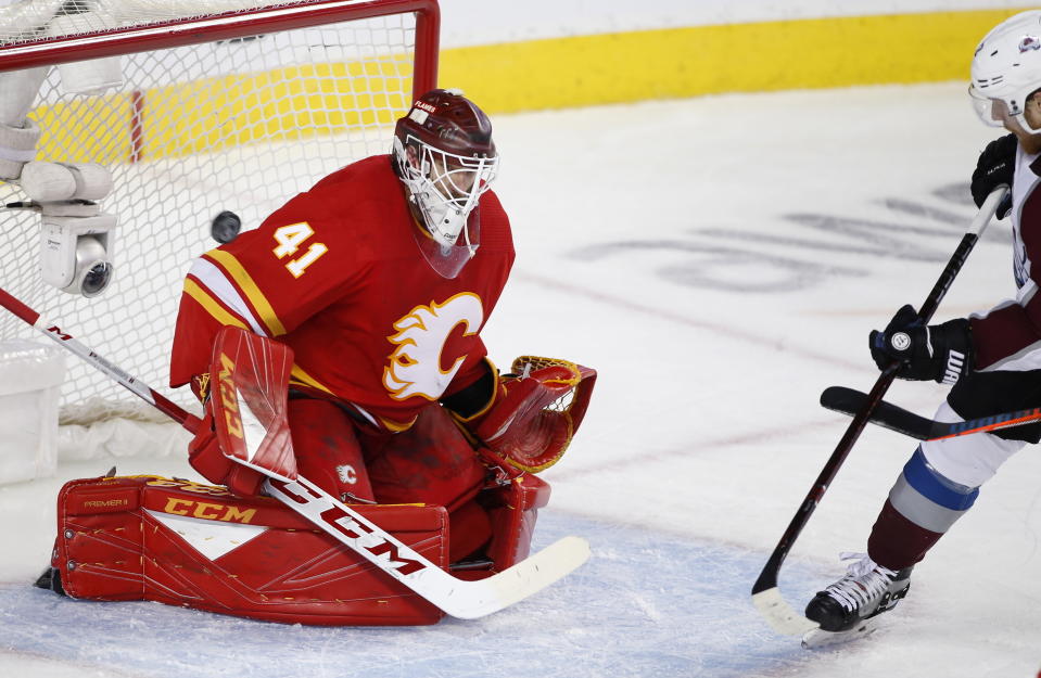 Colorado Avalanche left wing Gabriel Landeskog, right, watches a shot by teammate Colin Wilson go in for a goal on Calgary Flames goalie Mike Smith during the second period of Game 5 of an NHL hockey first-round playoff series Friday, April 19, 2019, in Calgary, Alberta. (Larry MacDougal/The Canadian Press via AP)