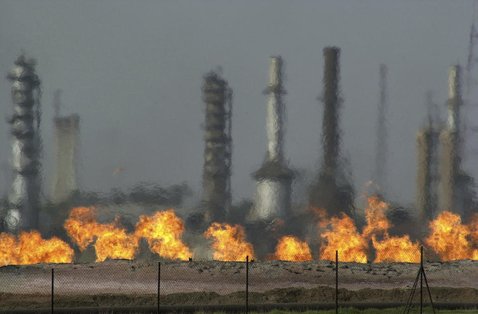 FILE - In this Jan. 24, 2004 file photo, fires flare off the gas from crude oil at Iraq's oldest oil processing plant in the northern Iraqi town of Baba Gurgur, outside of Kirkuk, Iraq's Oil Ministry says Iraq has resumed exports from its oil fields around Kirkuk, one year after the city was seized by federal forces from the autonomous Kurdish administration in the north of the country. (AP Photo/Khalid Mohammed, File)