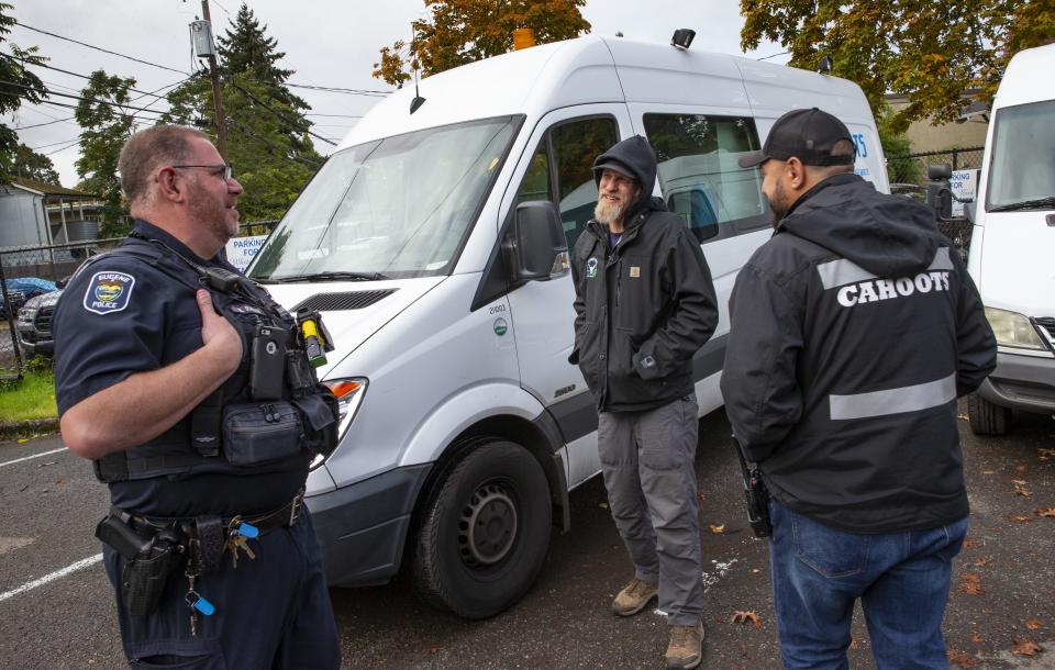 Eugene Police officer Bo Rankin, left, meets with Cahoots administrative coordinator Ben Brubaker and emergency crisis worker Matt Eads, right, after working a shift together as part of the Community Outreach Response Team in Eugene.