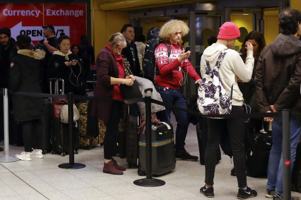 People wait in the departures area at Gatwick airport, as the airport remains closed after drones were spotted over the airfield last night and this morning, in Gatwick, England, Thursday, Dec. 20, 2018. Drones spotted over the runway forced the shutdown of London's Gatwick Airport on Thursday during one of the busiest times of the year, stranding or delaying tens of thousands of Christmas-season travelers and setting off a hunt for the operator of the intruding aircraft. (AP Photo/Tim Ireland)