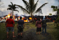 <p>Community members watch as a home is destroyed by lava from a Kilauea volcano fissure in Leilani Estates, on Hawaii’s Big Island, on May 25, 2018 in Pahoa, Hawaii. (Photo: Mario Tama/Getty Images) </p>