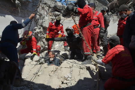 Iraqi firefighters look for bodies buried under the rubble, of civilians who were killed after an air strike against Islamic State triggered a massive explosion in Mosul, Iraq March 27, 2017. REUTERS/Stringer