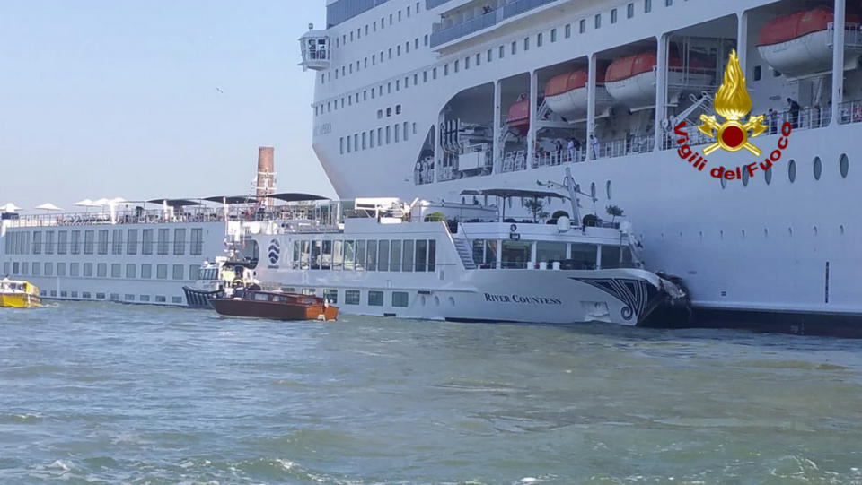 In this photo released by the Italian Firefighters, the MSC Opera cruise liner, a towering cruise ship, strikes a tourist river boat, left, Sunday, June 2, 2019, in Venice, Italy, injuring at least five people. The collision happened at about 8:30 a.m. on the Giudecca Canal, a major thoroughfare that leads to Saint Mark's Square. (Vigili del Fuoco via AP)