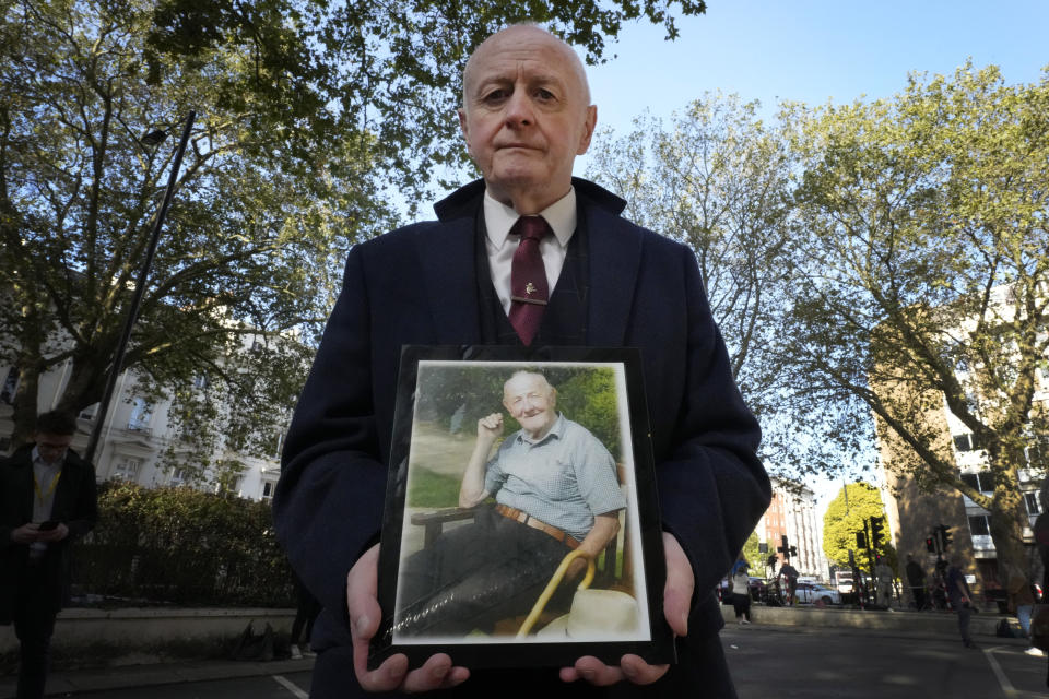 Larry Byrne holds a photograph of his father also called Larry Byrne as bereaved families demonstrate ahead of the opening hearing of Module 2 of the UK Covid 19 Inquiry, in London, Tuesday, Oct. 3, 2023. Bereaved families are coming together to protest the fact that in the module investigating core government decision making during the pandemic, only 1 bereaved family witness has been called to give evidence, out of the over 230,115 families bereaved by Covid 19. (AP Photo/Kirsty Wigglesworth)