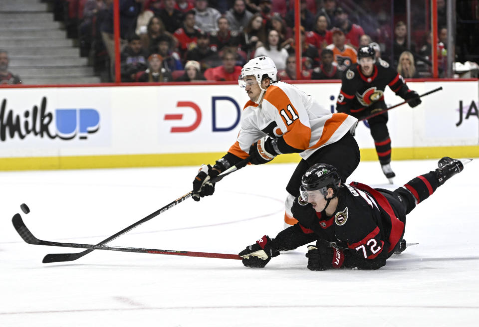 Ottawa Senators defenseman Thomas Chabot (72) falls on the ice as he knocks the puck away from Philadelphia Flyers right wing Travis Konecny (11) to prevent him from breaking away during the first period of an NHL hockey game, Saturday, Nov. 5, 2022 in Ottawa, Ontario. (Justin Tang/The Canadian Press via AP)