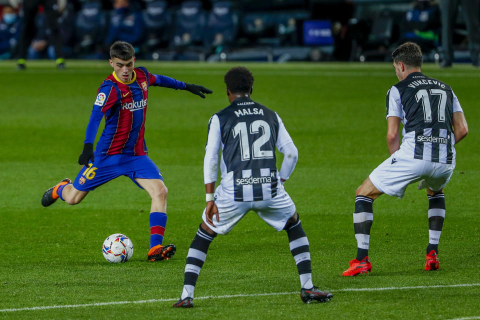 El mediocampista adolescente Pedri, izquierda, realiza un remate por el Barcelona en un duelo de la Liga ante el Levante, en el Camp Nou de Barcelona, España, el domingo 13 de diciembre de 2020. (AP Foto/Joan Monfort)