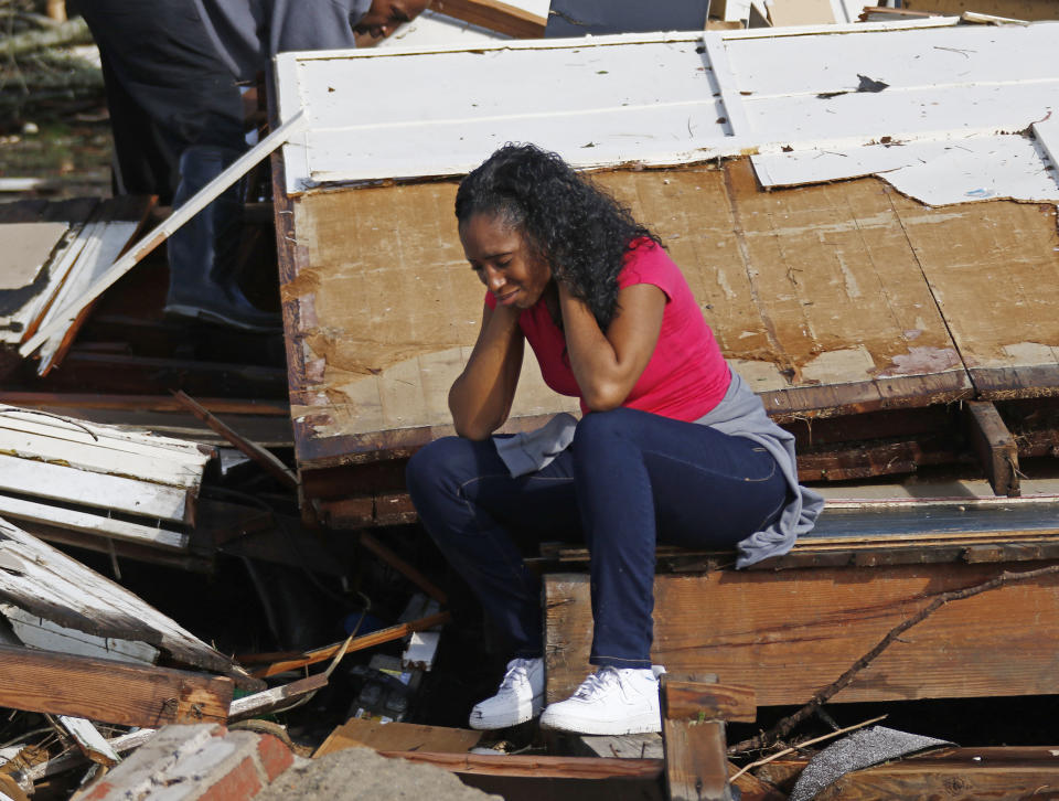 Shanise McMorris grieves on the slab of her Hattiesburg, Miss., home after an early tornado hit the city, Saturday, Jan. 21, 2017. The tornado was part of a wall of stormy weather traveling across the region, bringing with it rain and unstable conditions. (AP Photo/Rogelio V. Solis)