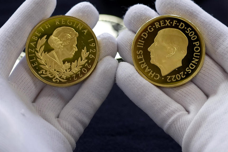 Coins featuring the portraits of King Charles III, right, and Queen Elizabeth II, are assessed during the "Trial of the Pyx,'' a ceremony that dates to the 12th Century in which coins are weighed in order to make certain they are up to standard, at the Goldsmiths' Hall in London, Tuesday, Feb. 7, 2023. A jury sat solemnly in a gilded hall in central London on Tuesday, presided over by a bewigged representative of the crown in flowing black robes, but there were no criminals in the dock. (AP Photo/Kin Cheung)