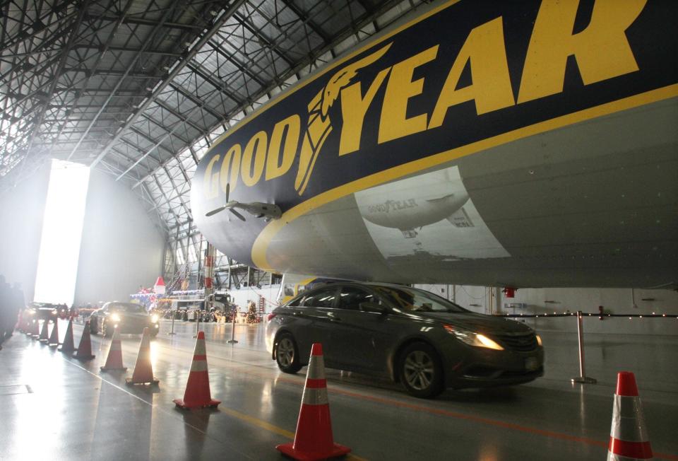 Cars drive slowly past the Goodyear blimp in 2018 after dropping off toys at the U.S. Marine Corps Reserve's Toys for Tots program at Goodyear's Wingfoot Lake hangar in Suffield Township.