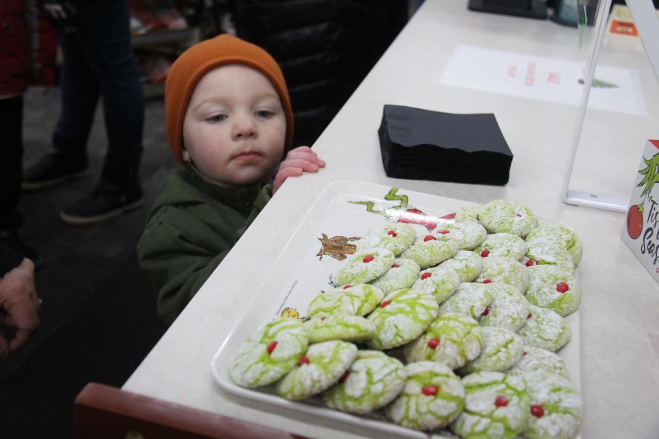 Ellie Cave, 3, eyes the Grinch cookies at Adel HealthMart during the Sip and Sample event as part of the Hometown Holiday Celebration on Friday, Dec. 2, 2022, in Adel.