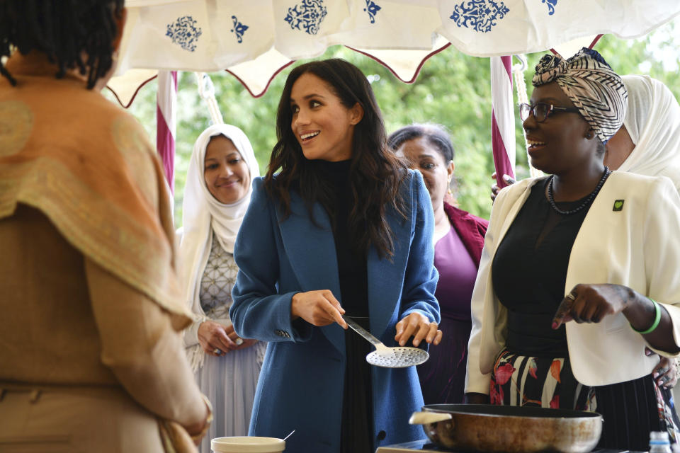 Meghan, the Duchess of Sussex, centre, reacts with one of the women behind the cookbook "Together" during a reception at Kensington Palace, in London, Thursday Sept. 20, 2018. The Duchess was joined by her mother Doria Ragland and husband Prince Harry for the launch of a cookbook aimed at raising money for victims of the Grenfell fire. (Ben Stansall/Pool Photo via AP)