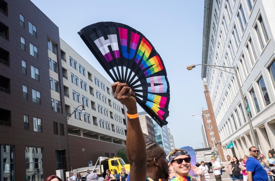 DeAndre Richardson waves a fan while walking in the Pride March representing US Bank on Saturday in Downtown Columbus.