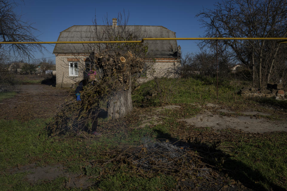 An elderly woman burns branches in the recently retaken village of Kyselivka, outskirts of Kherson, southern Ukraine, Tuesday, Nov. 15, 2022. As violence escalates in Ukraine abuse has become widespread, according to the United Nations. The situation is particularly concerning in the Kherson region where hundreds of villages, including the main city, were liberated from Russian occupation in early November, one of Ukraine’s biggest successes in the nearly 9-month-old war, dealing another stinging blow to the Kremlin. (AP Photo/Bernat Armangue)