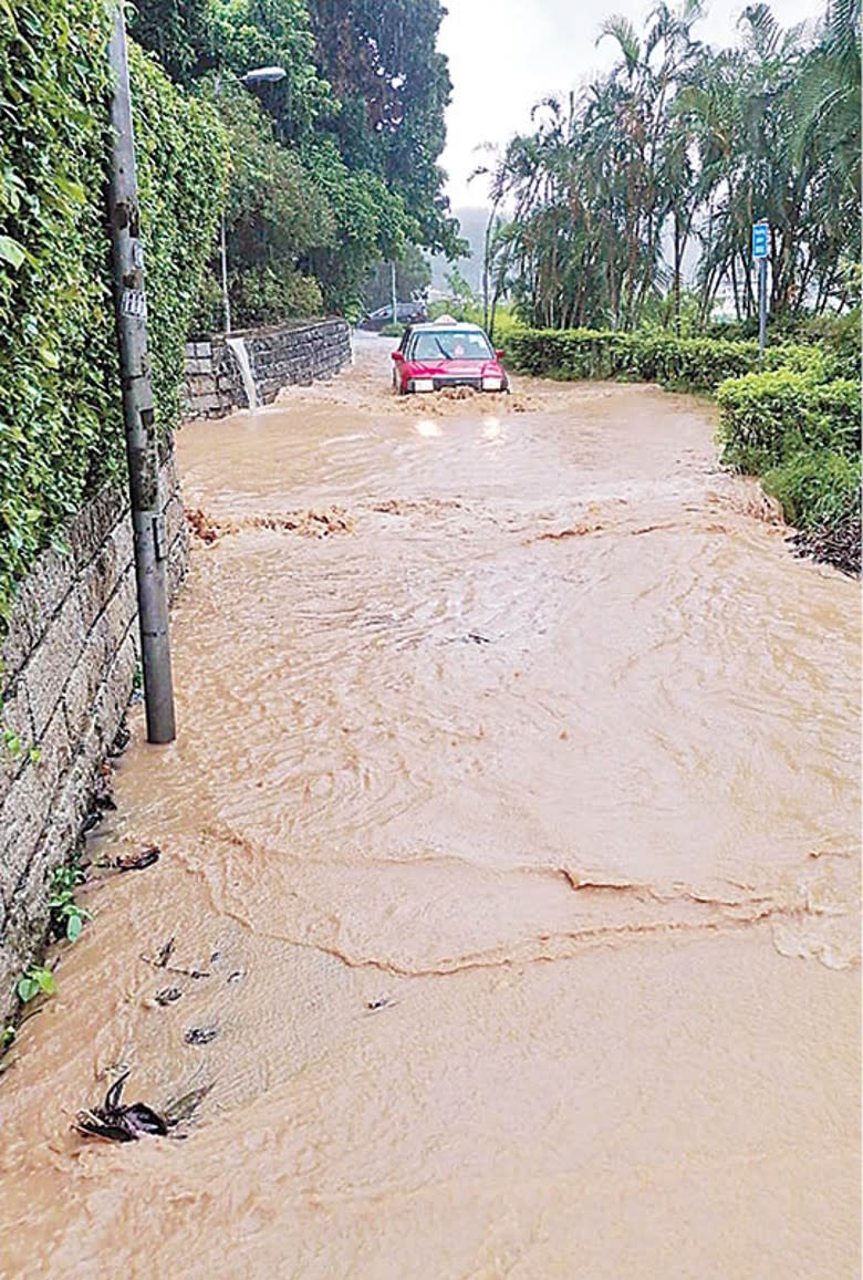 的士駛過被雨水淹浸的西貢道路。