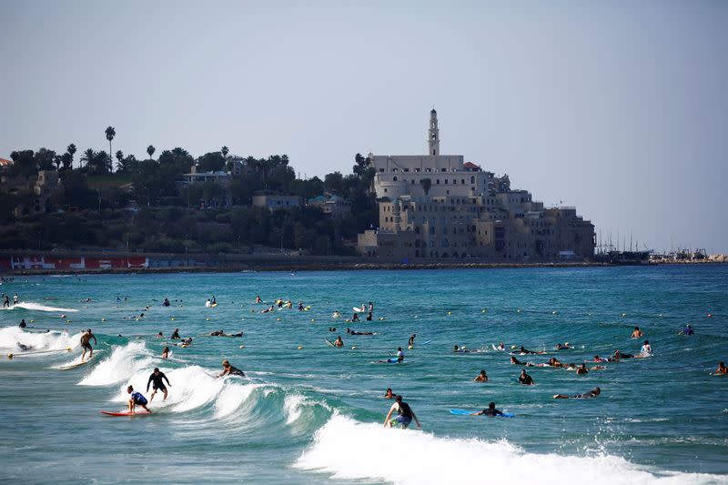 People surf in the Mediterranean ahead of Yom Kippur, the Jewish Day of Atonement and as Israel is set to tighten its second nationwide coronavirus disease (COVID-19) lockdown amid a rise in infections, later today, in Tel Aviv