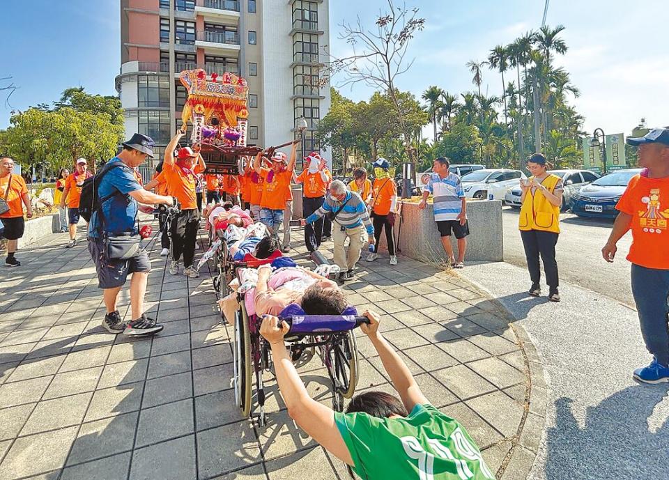 屏東市歸來慈天宮19日舉辦遶境，「歸來媽」首次至創世基金會屏東院賜福，並配合輪椅高度升高鑾轎讓植物人鑽轎腳。（謝佳潾攝）