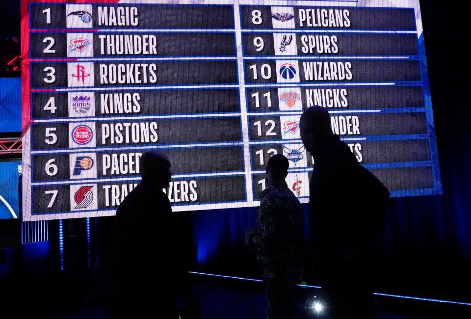 People look at the draft lottery order Tuesday night after the 2022 NBA Draft Lottery at McCormick Place in Chicago.