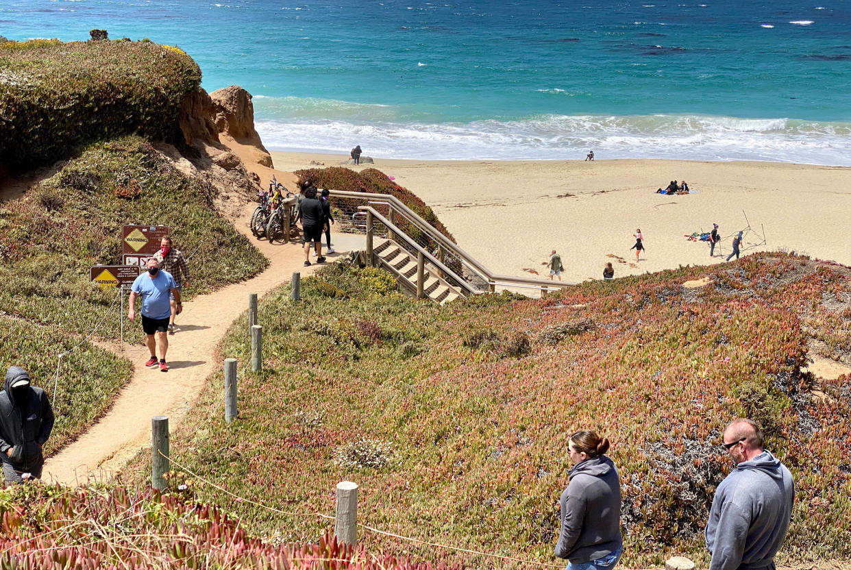 Tourists walk to the beach south of Monterey, Calif., on Aug. 1, 2020. (Daniel Slim / AFP via Getty Images file)
