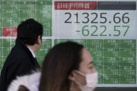 People walk past an electronic stock board showing Japan's Nikkei 225 index at a securities firm in Tokyo Friday, Feb. 28, 2020. Asian stock markets have fallen further on virus fears after Wall Street endured its biggest one-day drop in nine years. (AP Photo/Eugene Hoshiko)