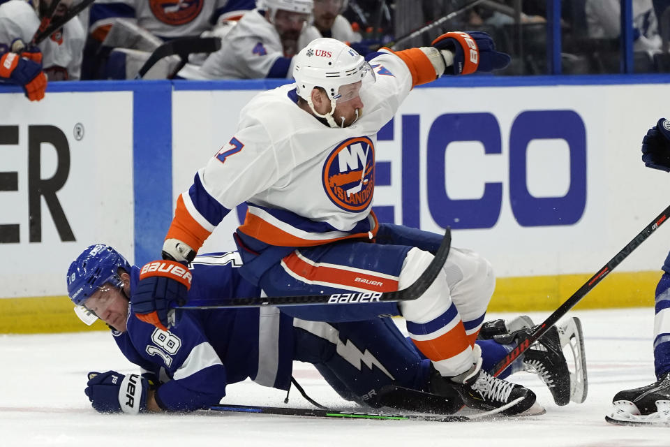 New York Islanders right wing Leo Komarov (47) falls over Tampa Bay Lightning left wing Ondrej Palat (18) during the third period in Game 1 of an NHL hockey Stanley Cup semifinal playoff series Sunday, June 13, 2021, in Tampa, Fla. (AP Photo/Chris O'Meara)