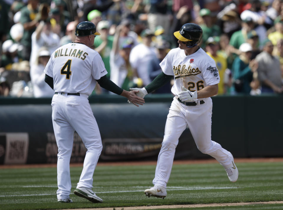 Oakland Athletics' Matt Chapman, right, is congratulated by third base coach Matt Williams (4) after hitting a home run against the Los Angeles Angels in the seventh inning of a baseball game Monday, May 27, 2019, in Oakland, Calif. (AP Photo/Ben Margot)