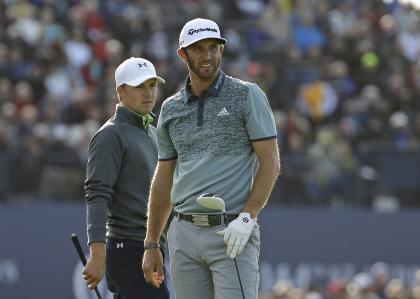 Dustin Johnson, left, follows his drive on 18 as Jordan Spieth looks on. (AP)