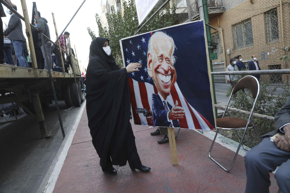 A demonstrator carries a banner with a caricature of the U.S. President Joe Biden in a rally in front of the former U.S. Embassy commemorating the anniversary of its 1979 seizure in Tehran, Iran, Thursday, Nov. 4, 2021. The embassy takeover triggered a 444-day hostage crisis and break in diplomatic relations that continues to this day. (AP Photo/Vahid Salemi)