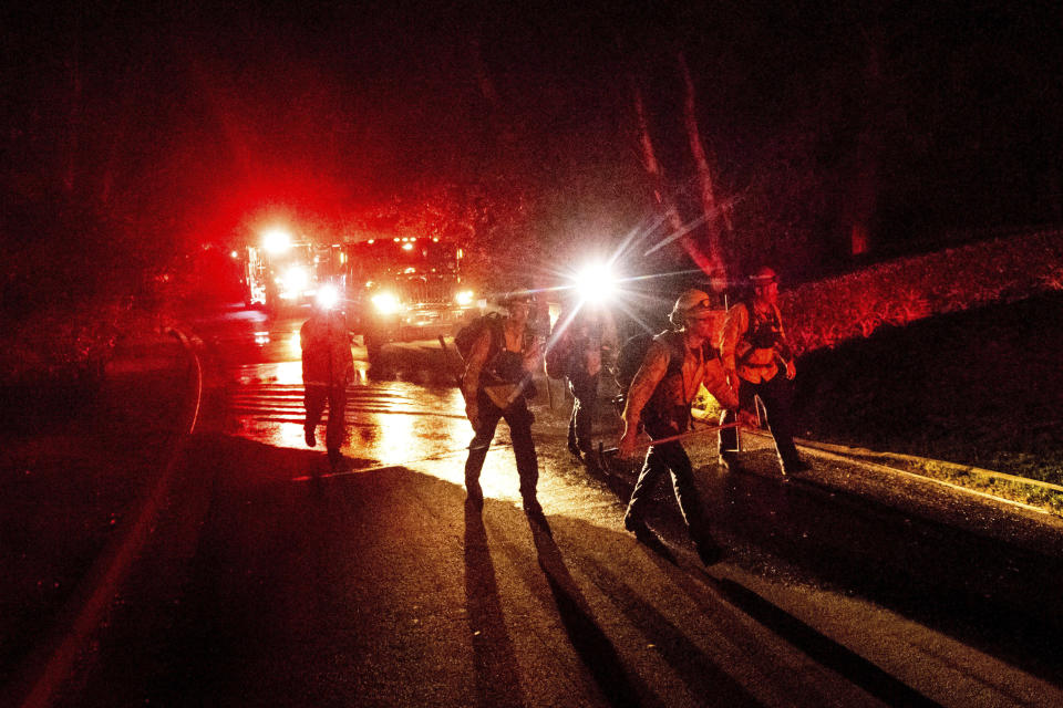 Firefighters work to contain a wildfire burning off Merrill Dr. in Moraga, Calif., on Thursday, Oct. 10, 2019. Police ordered evacuations as the fast-moving wildfire spread in the hills of the San Francisco Bay Area community .The area is without power after Pacific Gas & Electric preemptively cut service hoping to prevent wildfires during dry, windy conditions throughout Northern California. (AP Photo/Noah Berger)