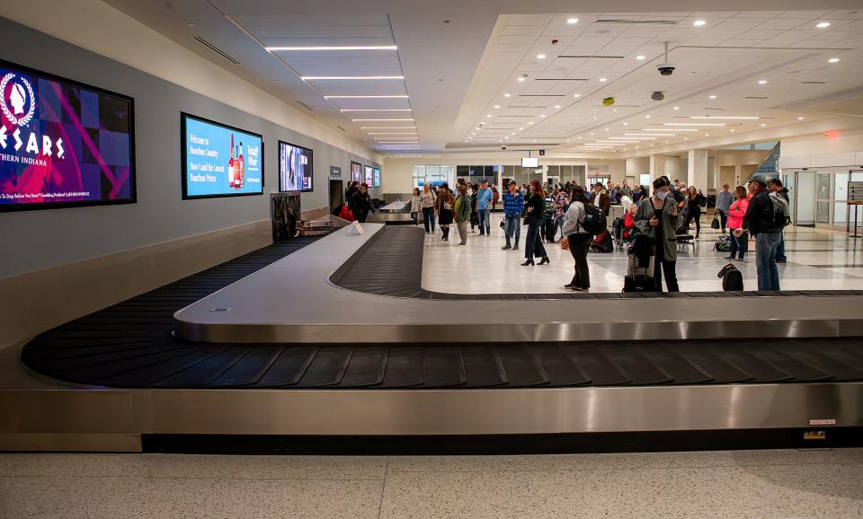 Holiday travelers wait for their bags after arriving at Muhammad Ali International Airport. Four new modern bag belts were recently installed and are now up and running as part of a $10 million dollar SDF Next program. Nov. 21, 2023.