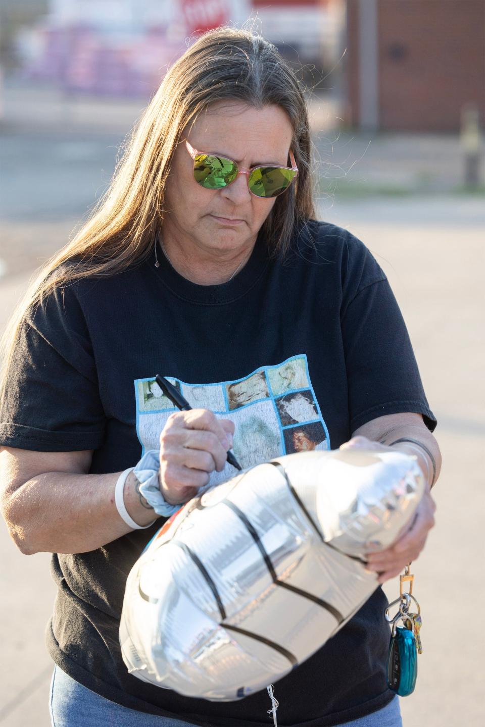 Robin Broad-Showalter, widow of Michael Broad, writes a personal message to him before she releases a balloon to mark the 20th anniversary of his unsolved death.