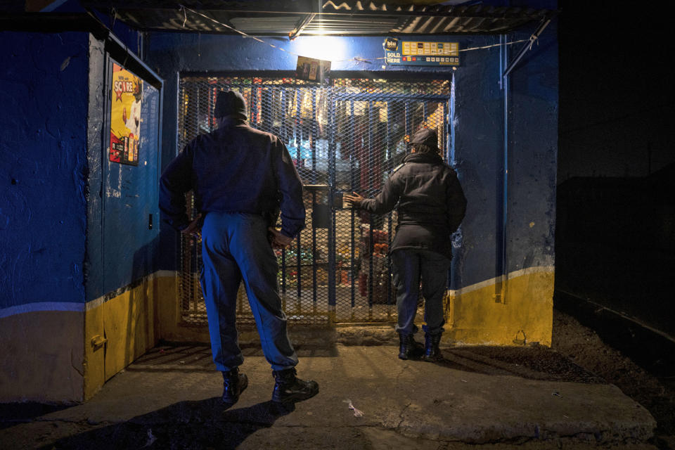 Police order a tuck shop to close business for the day while on patrol in Soweto, South Africa, Tuesday, July 12, 2022 in search of illegal firearms following the weekend shooting in a bar which claimed the lives of 16 people. South African police are searching for illegally-held guns in patrols of Johannesburg's Soweto township, following a spate of bar shootings that have rocked the nation. (AP Photo/Shiraaz Mohamed)