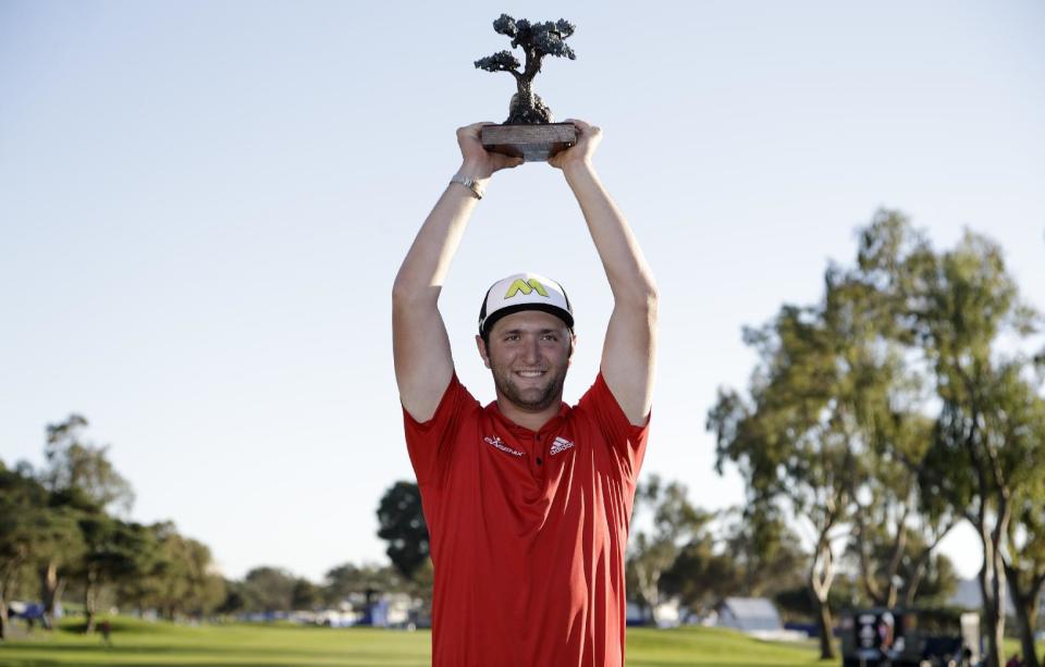 Jon Rahm, of Spain, holds the trophy after winning the Farmers Insurance Open golf tournament Sunday, Jan. 29, 2017, at Torrey Pines Golf Course in San Diego. (AP Photo/Gregory Bull)