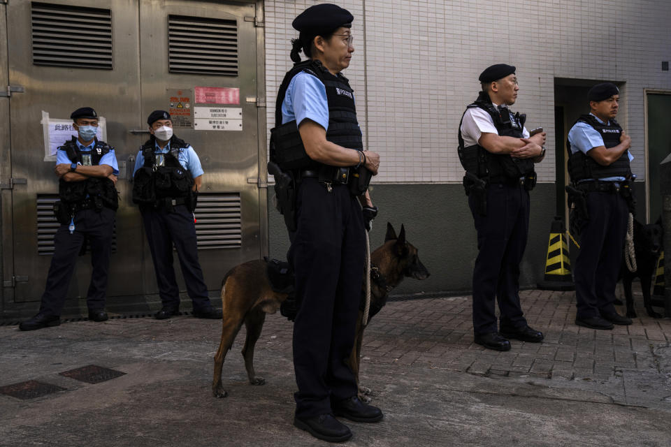 Police officers patrol outside a polling station during the District Council elections in Hong Kong, Sunday, Dec. 10, 2023. Residents went to the polls on Sunday in Hong Kong's first district council elections since an electoral overhaul was implemented under Beijing's guidance of “patriots” administering the city, effectively shutting out all pro-democracy candidates.(AP Photo/Louise Delmotte)